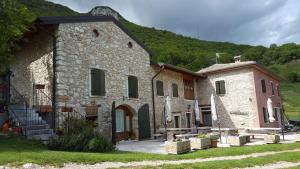 ein großes Steingebäude mit einem Hügel im Hintergrund in der Unterkunft Agriturismo Lusani in Caprino Veronese