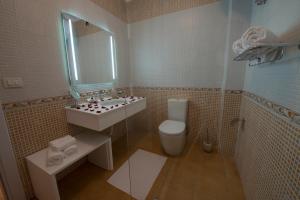 y baño con lavabo, aseo y espejo. en Hotel de Charme, en Tirana