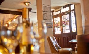 a table in a restaurant with chairs and a door at The Angel Inn Hotel in Pershore