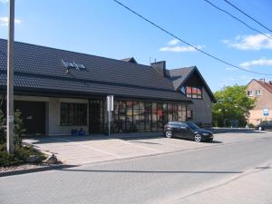 um carro estacionado num parque de estacionamento em frente a um edifício em Molo Užeiga Inn em Klaipėda