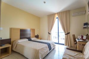 Postel nebo postele na pokoji v ubytování Ticho's Greenblu Hotel