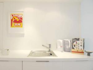 a white kitchen counter with a sink in it at Minimalistic In Premium Location in Brussels
