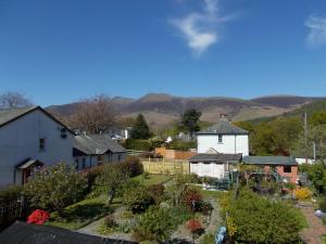 a small village with a white house and mountains in the background at Swiss Court Guest House in Keswick