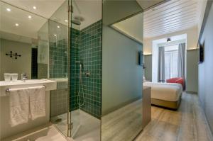 
a bathroom with a shower, tub, and sink at Vincci Baixa in Lisbon
