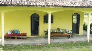 a yellow house with a table on a patio at Hostel Tucupi in Soure