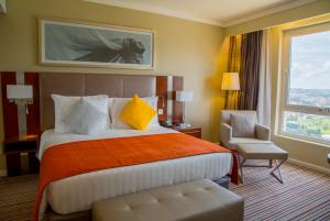 a hotel room with a bed and a chair and a window at Park Inn by Radisson, Kigali in Kigali +88 photos