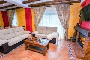 a living room with a couch and a fireplace at Casa Valle del Genal in Igualeja