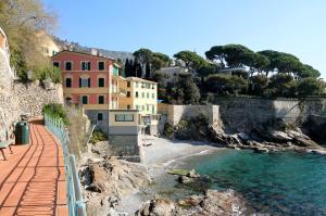 ジェノヴァにあるHouse Il Nido by Holiday Worldの家屋と水辺のあるビーチの景色を望めます。