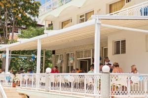 a group of people sitting on the porch of a house at Hotel Panorama in Sveti Vlas