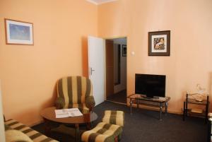 a living room with a couch and a tv at Penzion Rotunda in Liptovský Mikuláš