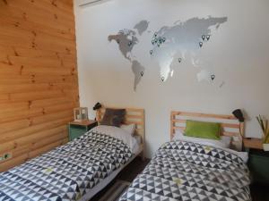 a bedroom with two beds and a world mural on the wall at Laganini in Samobor