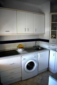 a kitchen with a washing machine and a sink at Rosa Nautica 301 in La Herradura