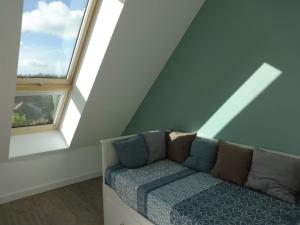 um sofá num quarto com duas janelas em Au Coeur des Caps em Audinghen