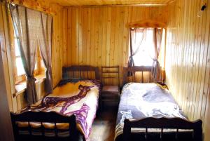 1 dormitorio con 2 camas en una cabaña de madera en Samtsikhe, en Dart'lo