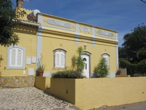 a yellow house with plants in front of it at Casa Manuel in São Brás de Alportel