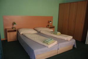 1 dormitorio con 2 camas y toallas. en Penzion Rotunda, en Liptovský Mikuláš