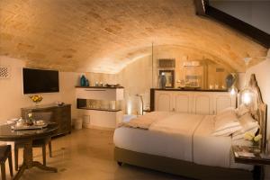 a bedroom with a large white bed and a table at Hotel Don Ferrante in Monopoli