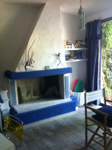 een woonkamer met een open haard met een blauwe mantel bij Villa stella di mare in Capitana