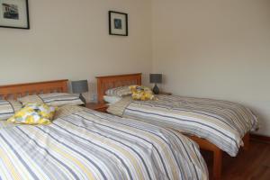 Dos camas una al lado de la otra en un dormitorio. en Harry's House, en Ballinrobe