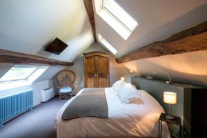 a bedroom with a large bed in a attic at Le Clos du Verger in Levernois