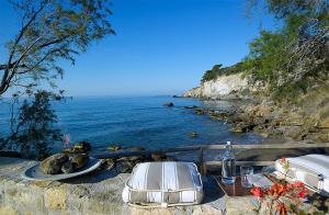 stół i krzesła siedzące obok wody w obiekcie Beachfront Villas on Crete - Pelagaios w mieście Ferma