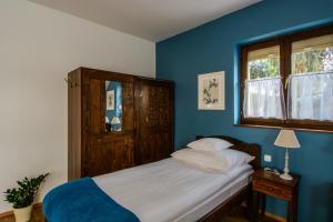 エゲルにあるToszkána Apartmanの青い壁のベッドルーム1室(ベッド1台付)