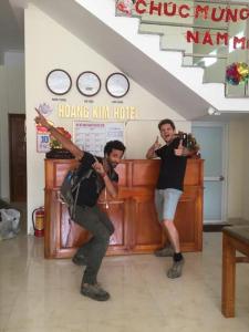 two men standing in a room with their arms in the air at Hoang Kim Ha Giang Hotel in Ha Giang