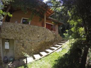 a stone wall with stairs next to a house at Sitio Rosa de Minas in Gonçalves