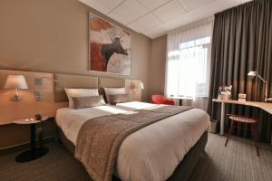 a hotel room with a large bed and a window at Mercure Périgueux Centre Historique in Périgueux +103 photos