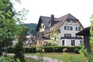 a large white building in the middle of a town at Garni Hotel Adler Post in Baiersbronn