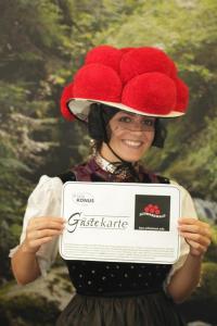 una mujer con un sombrero y sosteniendo un cartel en Garni Hotel Adler Post, en Baiersbronn