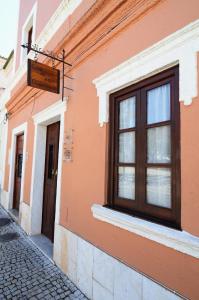 um edifício laranja com uma janela numa rua em Casa do Jardim em Silves