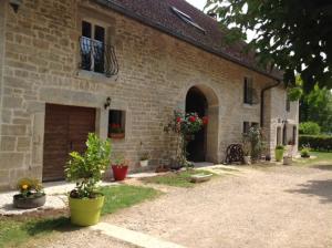 een bakstenen gebouw met een garage en enkele potplanten bij Chez Robert et Catherine in Dompierre-sur-Mont