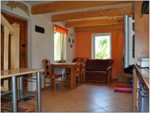 a living room with a couch and a table and chairs at Muzyczna Zagroda in Pietzonken +5 photos