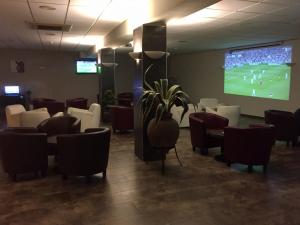 a room with chairs and a large screen with a game at Hotel Stella Maris in Blanes