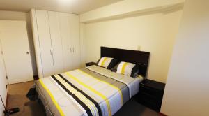 1 dormitorio con 1 cama con manta a rayas en Departamento Lima, en Lima