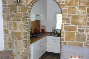 a kitchen with an archway in a stone wall at Bungalow am Werratal Radwanderweg in Breitungen +15 photos