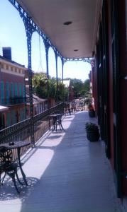 a walkway with benches and tables on a building at Inn on St. Peter, a French Quarter Guest Houses Property in New Orleans