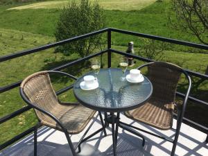 a glass table and two chairs on a balcony at VIP Apartments & Room in Rakovica