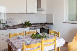 a kitchen with a table with a bowl of fruit on it at Apartmani Mudronja in Murter