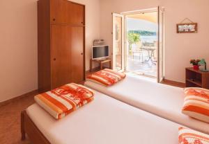 a bedroom with two beds and a large window at Apartmani Mudronja in Murter