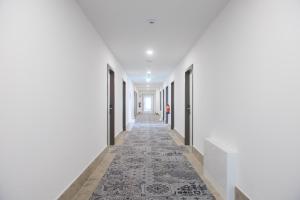 an empty corridor with white walls and a carpeted hallway at K-Apart Hotel & Boardinghouse in Hürth