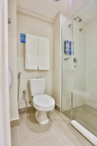 a bathroom with a toilet and a shower at Sleep Inn Aeroporto de Guarulhos - São Paulo in Guarulhos