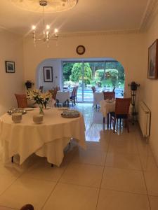 a dining room with tables and chairs and a large window at Norfolk House in Maidenhead +12 photos