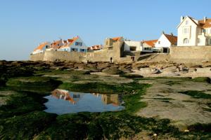 a group of houses on the shore with a pool of water at Les Carcahutes in Audresselles