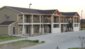 einen Blick nach außen auf ein Gebäude mit einem Parkplatz in der Unterkunft Eagle's Den Three Rivers Texas a Travelodge by Wyndham in Three Rivers