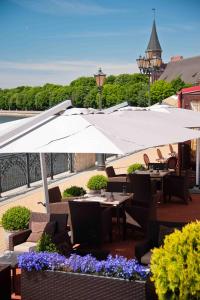 an outdoor patio with tables and umbrellas and flowers at Skipper Hotel in Kaliningrad
