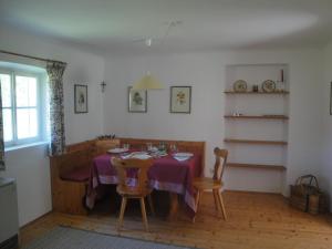 ein Esszimmer mit einem lila Tisch und Stühlen in der Unterkunft Jägerhaus in Hintersee