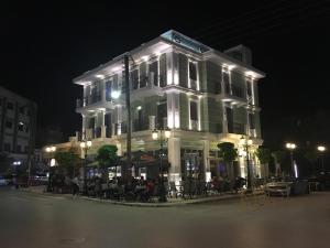 un edificio con gente sentada fuera de él por la noche en Casa Verde en Lagadas