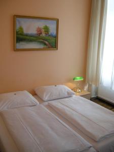 a bed in a bedroom with a picture on the wall at Pension Schottentor in Vienna